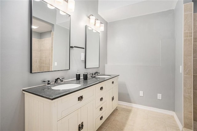 bathroom with double vanity, baseboards, and a sink