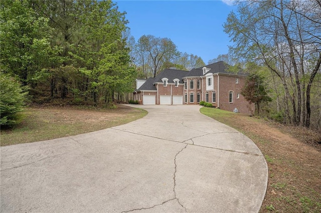 view of front of property with concrete driveway, a garage, and brick siding