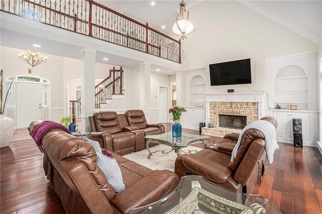 living room featuring ornamental molding, built in features, a chandelier, stairway, and hardwood / wood-style floors
