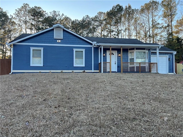 ranch-style home featuring a garage, a front yard, and a porch