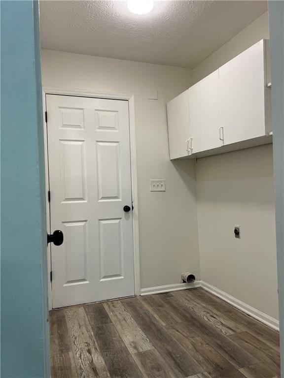 laundry area with dark hardwood / wood-style flooring, cabinets, hookup for an electric dryer, and a textured ceiling