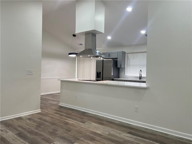 kitchen featuring island range hood, gray cabinetry, kitchen peninsula, stainless steel refrigerator with ice dispenser, and dark wood-type flooring