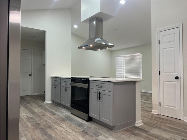 kitchen with light hardwood / wood-style flooring, gray cabinetry, electric range, island range hood, and kitchen peninsula