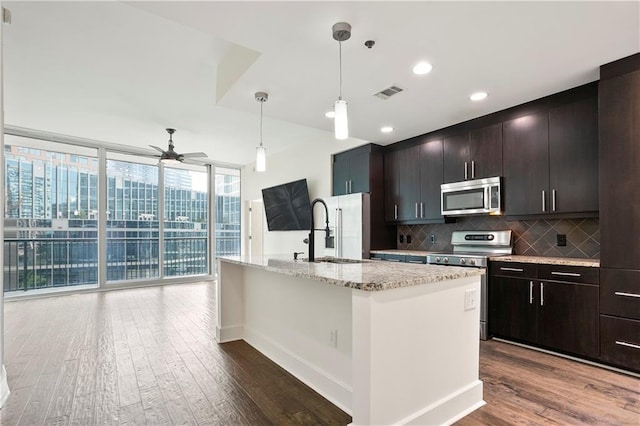 1080 Peachtree St NE Unit 804, Atlanta, GA 30309 - kitchen featuring appliances with stainless steel finishes, a wall of windows, decorative backsplash, a ceiling fan, and dark wood-style floors