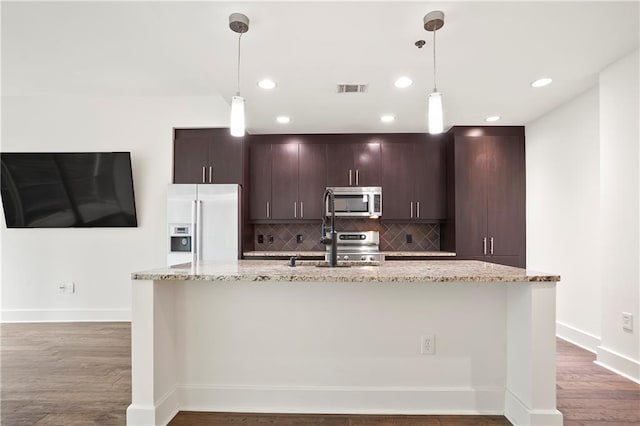 1080 Peachtree St NE Unit 804, Atlanta, GA 30309 - kitchen featuring high end white fridge, stainless steel microwave, decorative backsplash, an island with sink, and wood finished floors