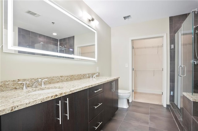 1080 Peachtree St NE Unit 804, Atlanta, GA 30309 - bathroom with a stall shower, double vanity, tile patterned flooring, and a spacious closet
