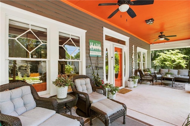 sunroom with plenty of natural light, an outdoor living space, and a ceiling fan