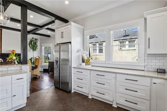 kitchen featuring decorative backsplash, plenty of natural light, beam ceiling, and stainless steel fridge with ice dispenser