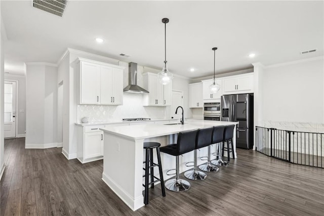 kitchen with wall chimney exhaust hood, appliances with stainless steel finishes, dark hardwood / wood-style flooring, and white cabinets