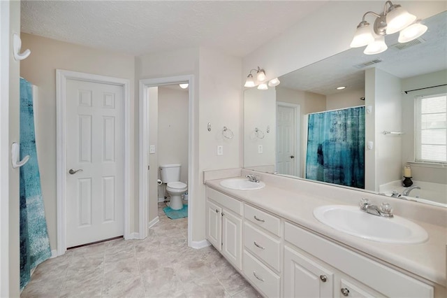 bathroom featuring vanity, a textured ceiling, and toilet