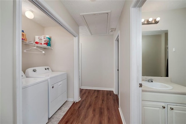 washroom featuring dark wood-type flooring, washer and clothes dryer, sink, and a textured ceiling