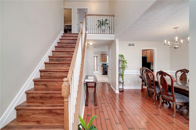 interior space with an inviting chandelier, hardwood / wood-style floors, and a textured ceiling