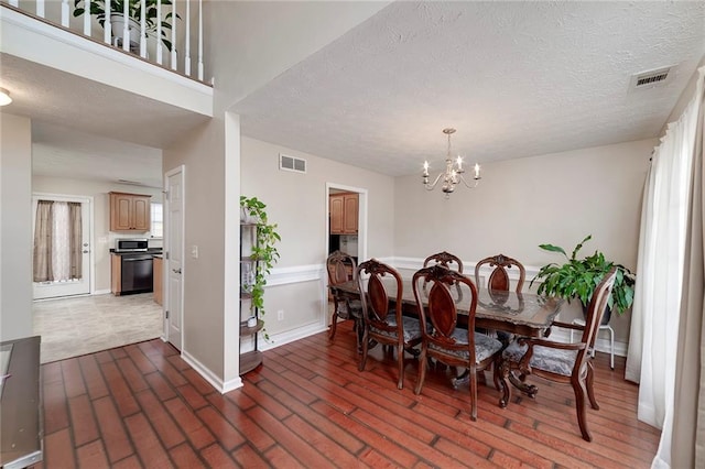 dining space featuring an inviting chandelier, a textured ceiling, and a wealth of natural light