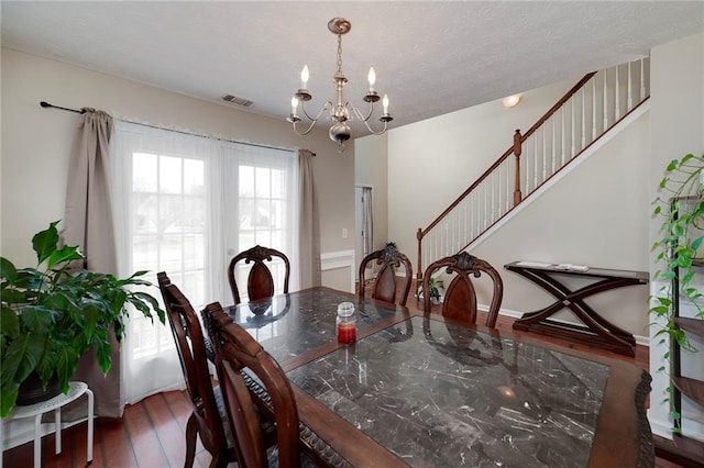 dining room featuring dark hardwood / wood-style flooring and an inviting chandelier