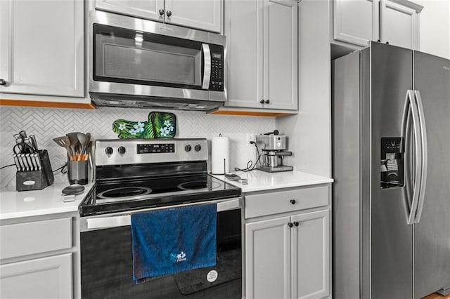 kitchen with tasteful backsplash, white cabinetry, and stainless steel appliances