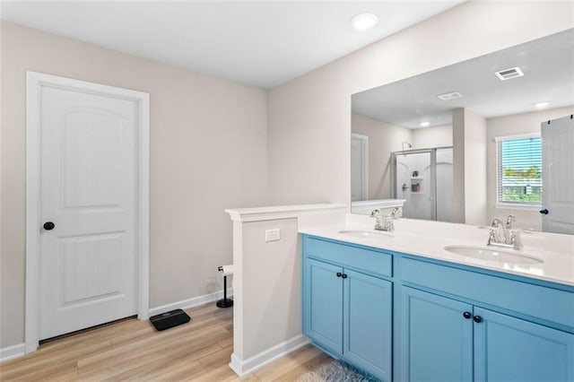 bathroom with hardwood / wood-style flooring, vanity, and walk in shower