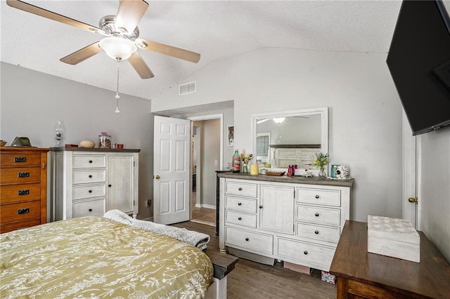 bedroom featuring vaulted ceiling, a textured ceiling, ceiling fan, and dark hardwood / wood-style floors