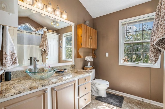 bathroom featuring vanity, vaulted ceiling, and toilet