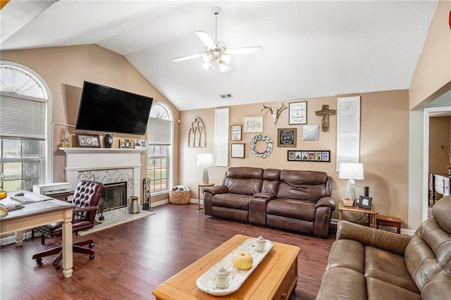 living room featuring lofted ceiling, a premium fireplace, ceiling fan, and dark hardwood / wood-style floors