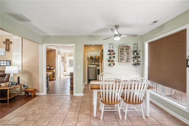 tiled dining area featuring washing machine and dryer and ceiling fan