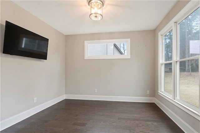 unfurnished room with dark wood-type flooring and a wealth of natural light