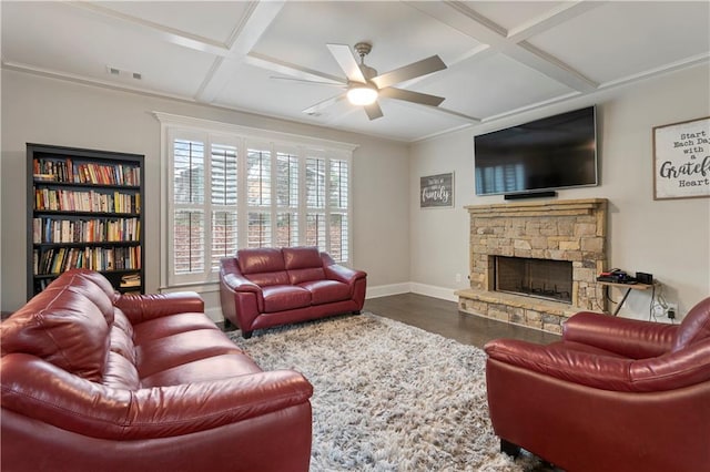 living room featuring coffered ceiling, ceiling fan, a stone fireplace, and dark wood-type flooring