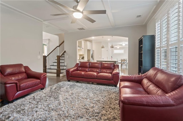 living room with coffered ceiling, ceiling fan, ornamental molding, and plenty of natural light