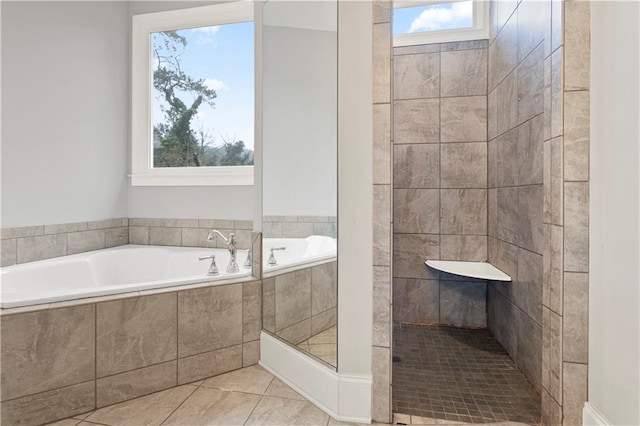 bathroom featuring shower with separate bathtub and tile floors