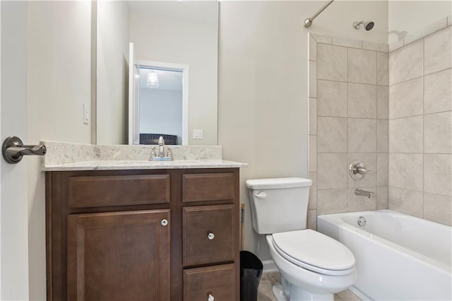 full bathroom with tiled shower / bath, toilet, and vanity