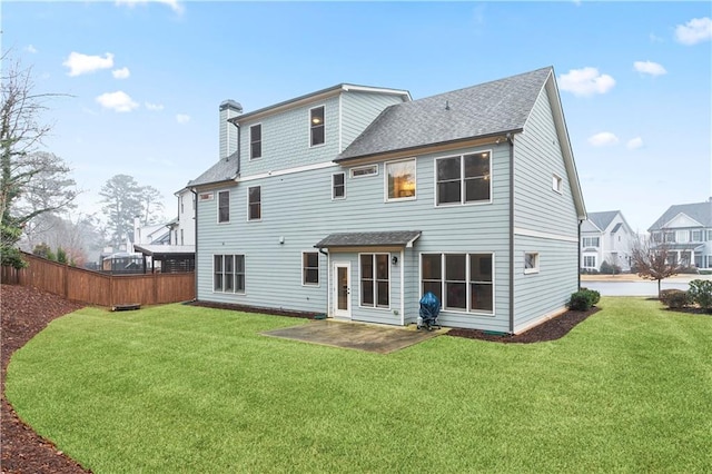 back of house with a lawn and a patio