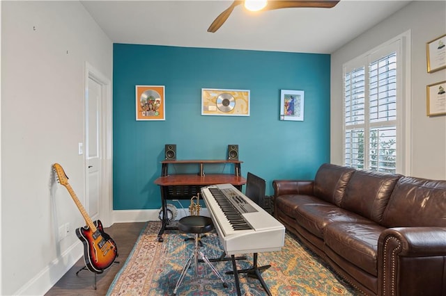 living room with ceiling fan and dark wood-type flooring