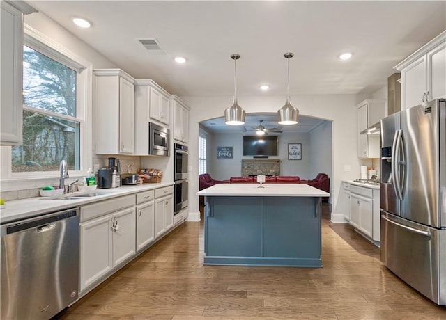 kitchen with white cabinets, appliances with stainless steel finishes, and a center island