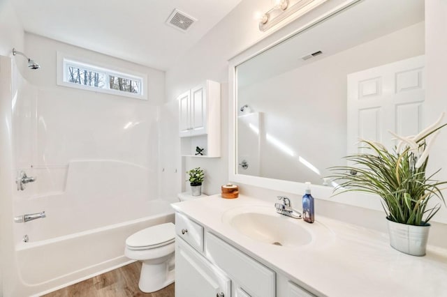 full bathroom featuring vanity, hardwood / wood-style flooring, shower / bathtub combination, and toilet