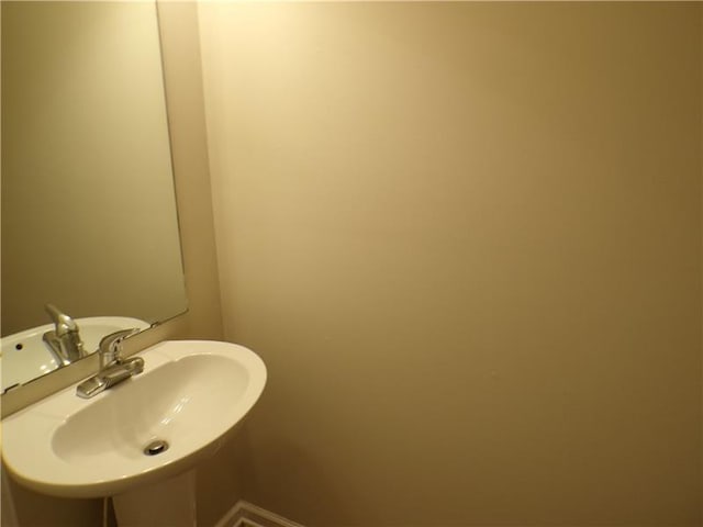 bathroom with a sink and baseboards