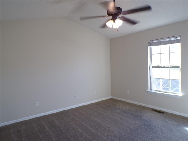 carpeted spare room featuring lofted ceiling, ceiling fan, and baseboards