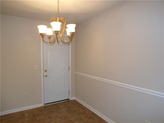 interior space featuring an inviting chandelier and baseboards