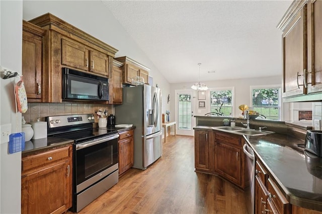64 River Mist Cir, Jefferson, GA 30549 - kitchen featuring stainless steel appliances, wood finished floors, dark countertops, vaulted ceiling, and a peninsula