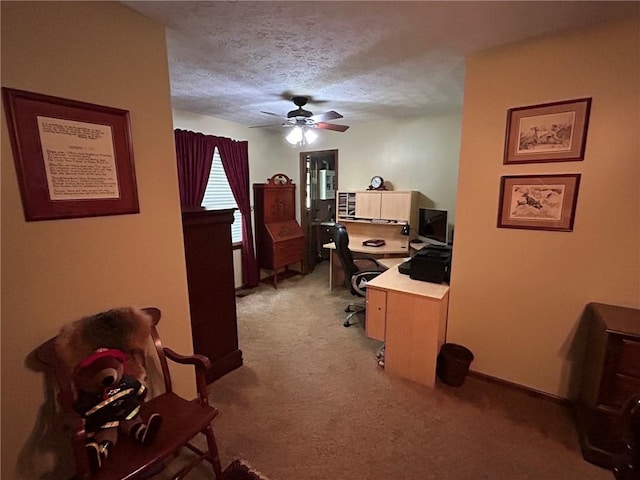 carpeted home office with a textured ceiling and ceiling fan