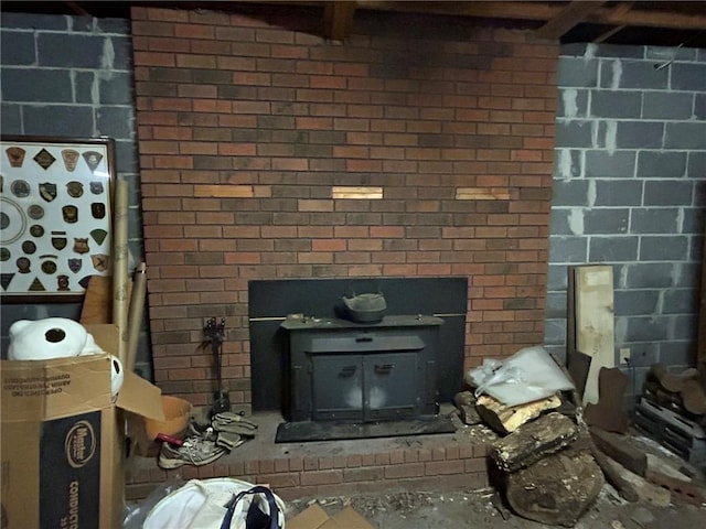 interior space featuring brick wall, a wood stove, and a fireplace