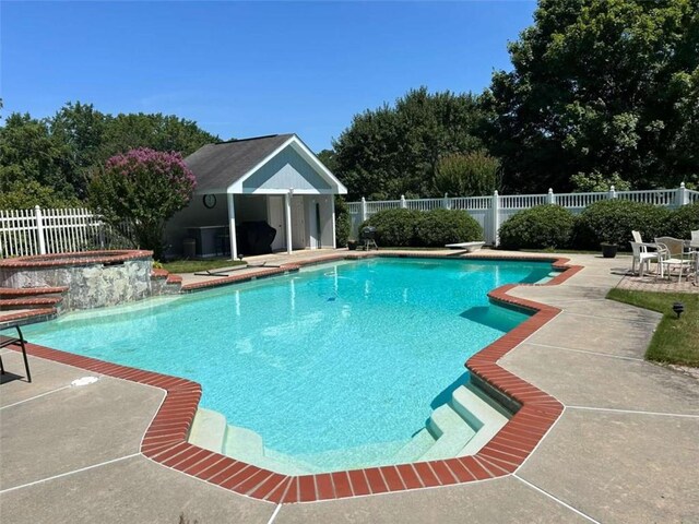 view of pool featuring a diving board and a patio