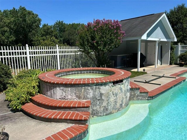 view of swimming pool with an in ground hot tub, a patio, and pool water feature