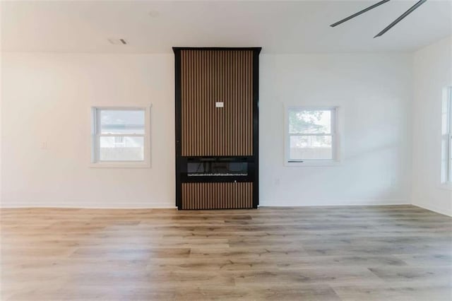 spare room featuring a healthy amount of sunlight and light wood-type flooring