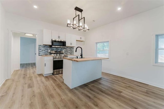 kitchen featuring a kitchen island with sink, white cabinetry, pendant lighting, and stainless steel appliances