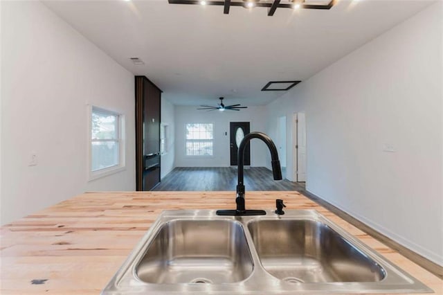 kitchen featuring ceiling fan, sink, and wooden counters