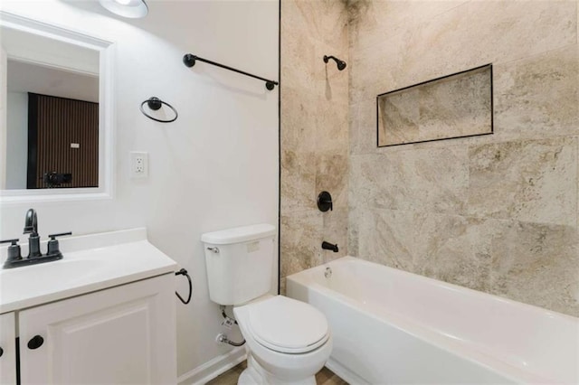 full bathroom featuring vanity, tiled shower / bath combo, and toilet