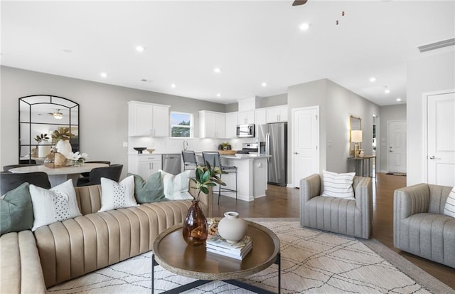 living area featuring light wood-type flooring, visible vents, recessed lighting, and a ceiling fan