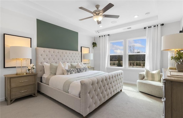 bedroom with visible vents, baseboards, recessed lighting, light carpet, and a tray ceiling