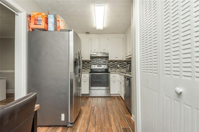 365 Winding River Dr Unit # E, Atlanta, GA 30350 - kitchen with appliances with stainless steel finishes, under cabinet range hood, white cabinetry, decorative backsplash, and dark wood finished floors