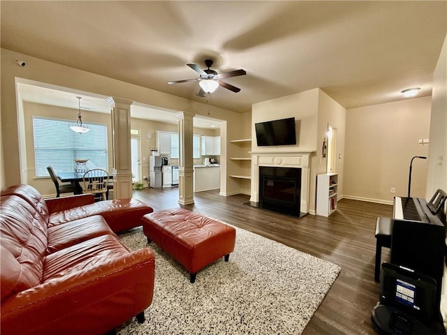 2351 Attewood Dr, Buford, GA 30519 - living room with dark wood finished floors, healthy amount of natural light, a ceiling fan, and decorative columns