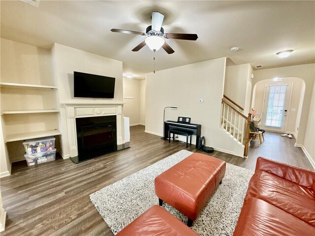 2351 Attewood Dr, Buford, GA 30519 - living room with arched walkways, wood finished floors, stairs, a ceiling fan, and a fireplace